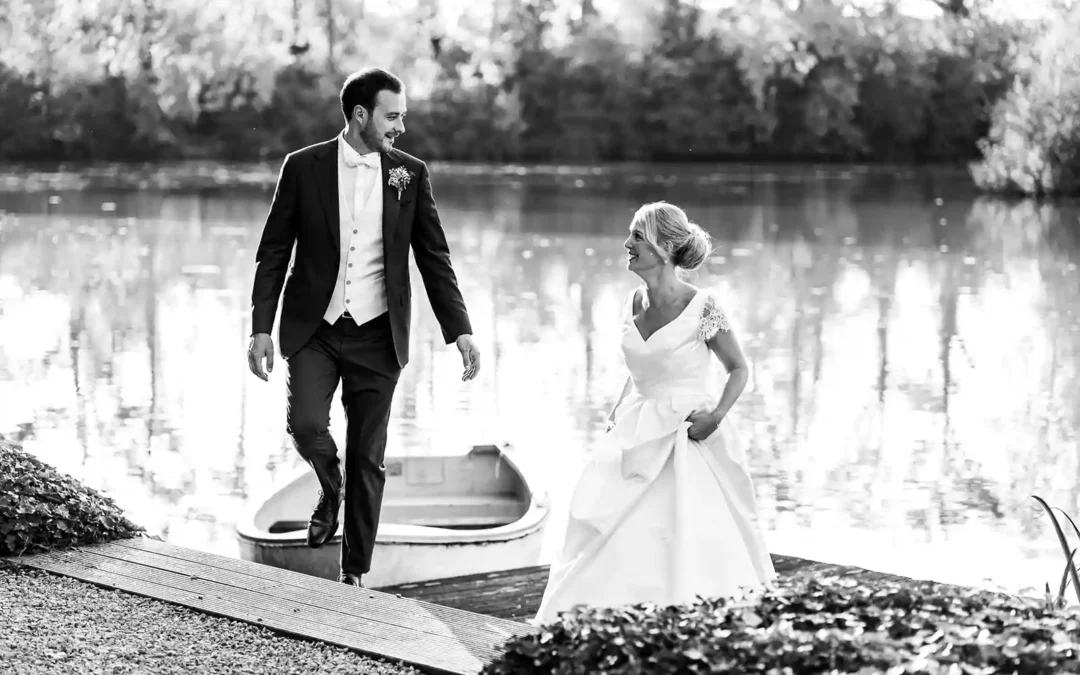 Un photographe de mariage haut de gamme à Monaco immortalise un couple de jeunes mariés se promenant au bord de l'eau.